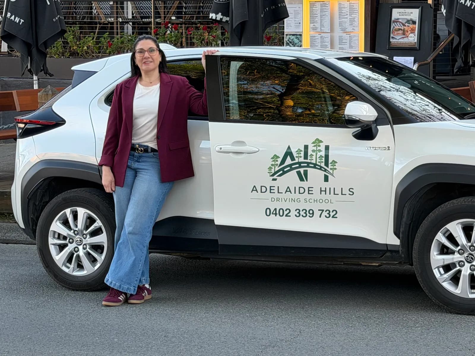 Driving instructor Lynne Cushnie standing beside her Adelaide Hills Driving School car in Hahndorf